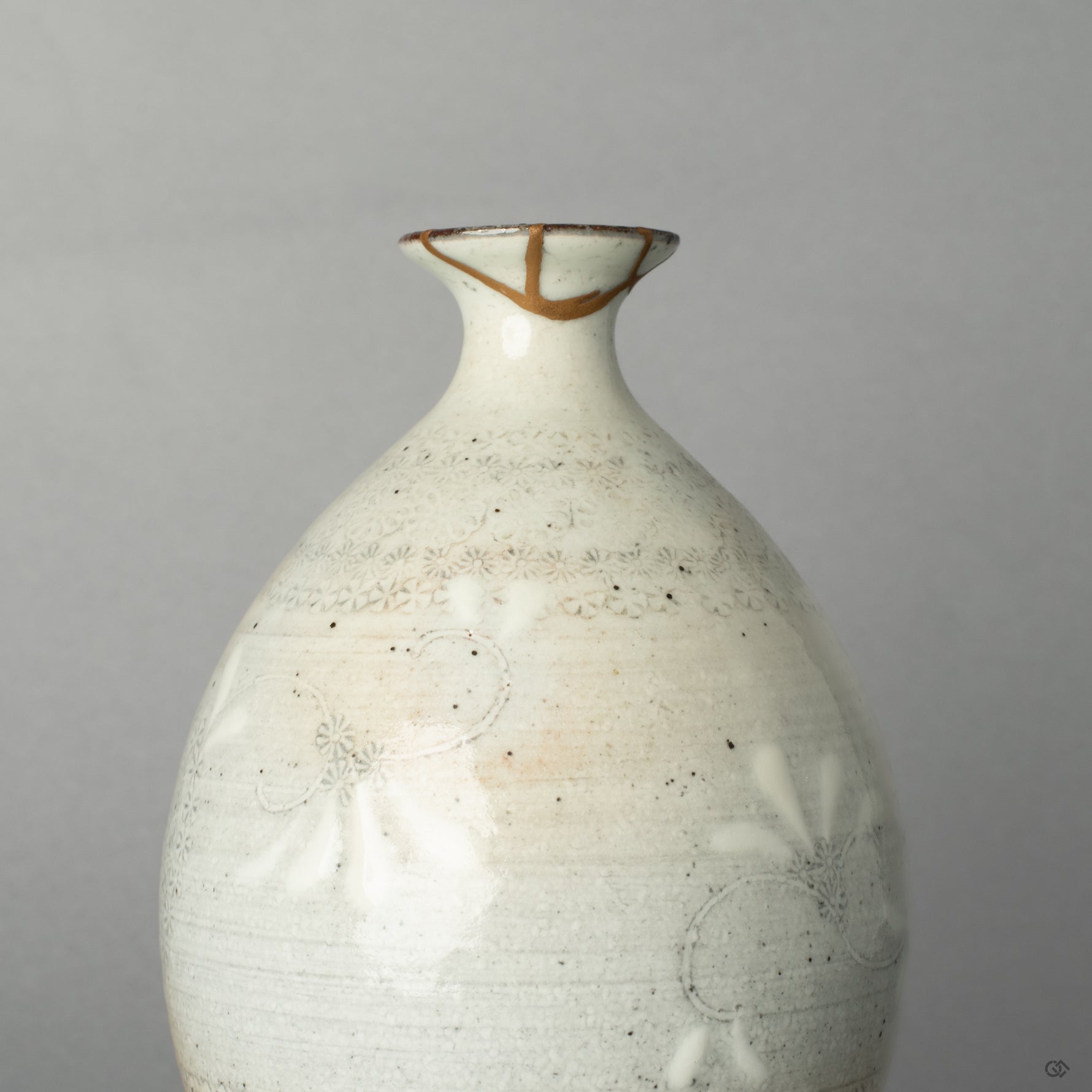 The shining 24K gold kintsugi seam on the ceramic surface, a quiet moment where the vessels journey becomes history made visible.