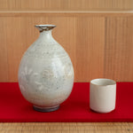 The kintsugi tokkuri put on the tatami and red felt, creating a moment of connection between the user, the vessel, and its renewed life.