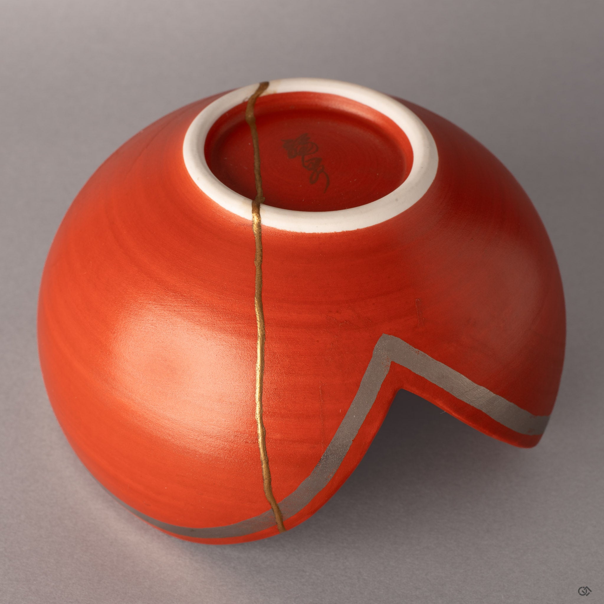 Gold kintsugi rivers carve new geography across vermillion Arita porcelain, each seam a story of resilience.