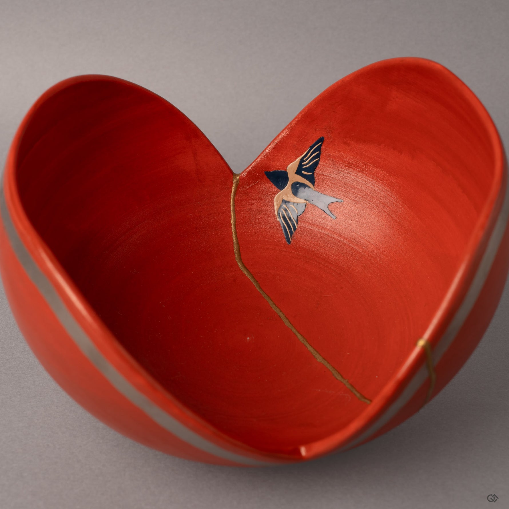 The urushi-e swallow emerges in lacquer paint beside gold kintsugi seams—two ancient arts united in one vessel.