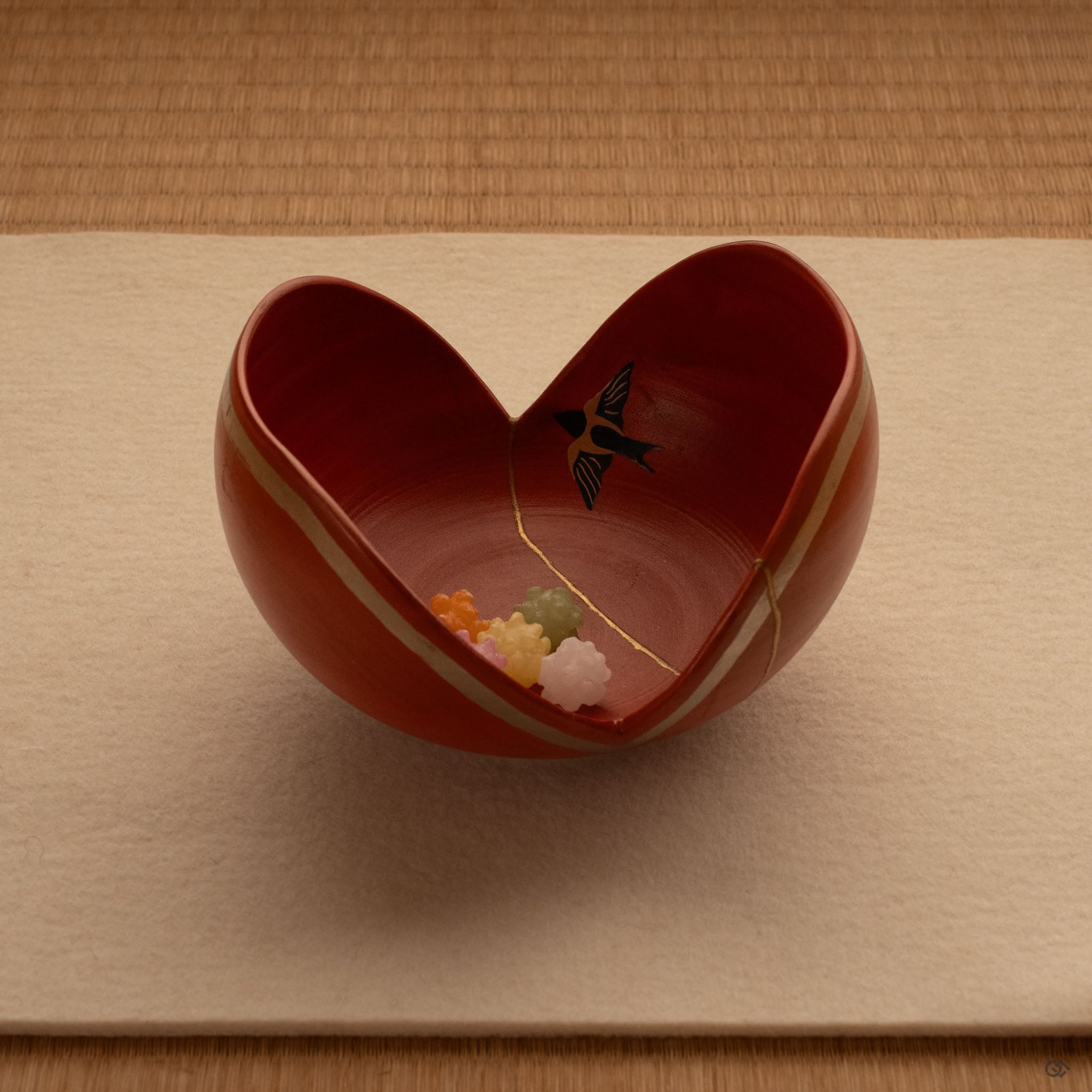 An Arita kintsugi bowl rests on tatami, the painted swallow catching light—a symbol of homecoming made tangible.