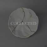 Arita ware bowl in matte white porcelain with pastel swirl panels, its break rejoined with natural urushi, 24K gold on the face and moss-green urushi beneath. Collected.