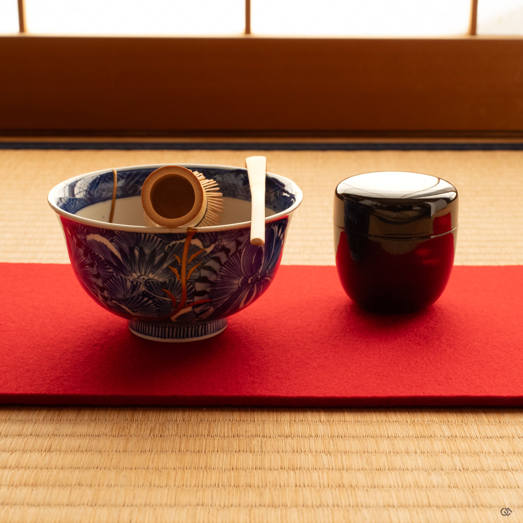 Ko-Imari kintsugi bowl with gold maki-e set on tatami in natural light, a moment of contemplation in porcelain and lacquer.