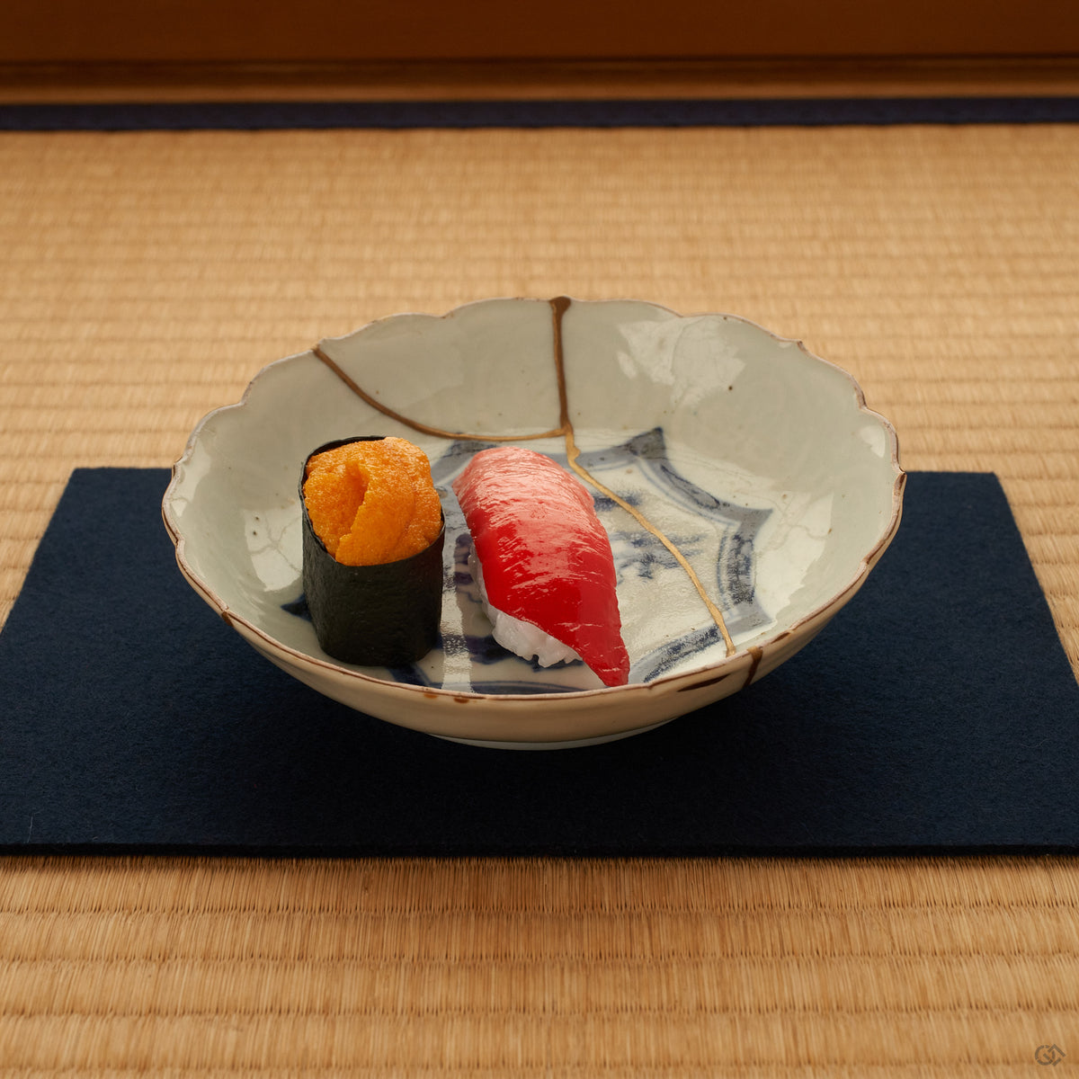 A kintsugi Ko-Imari bowl on tatami, soft light across its gold seam and cobalt landscape, an unhurried moment of conscious luxury.