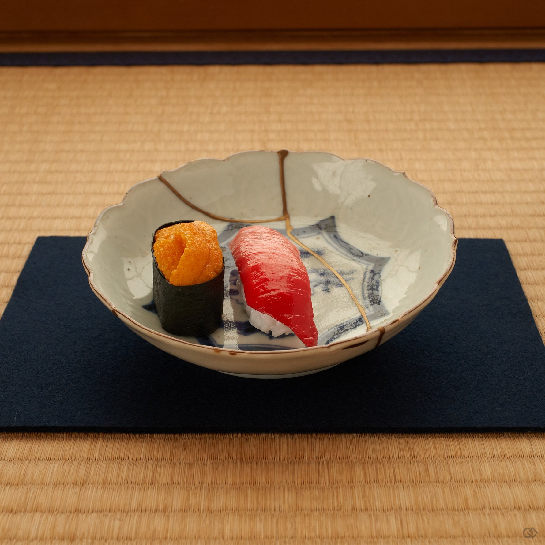 A kintsugi Ko-Imari bowl on tatami, soft light across its gold seam and cobalt landscape, an unhurried moment of conscious luxury.