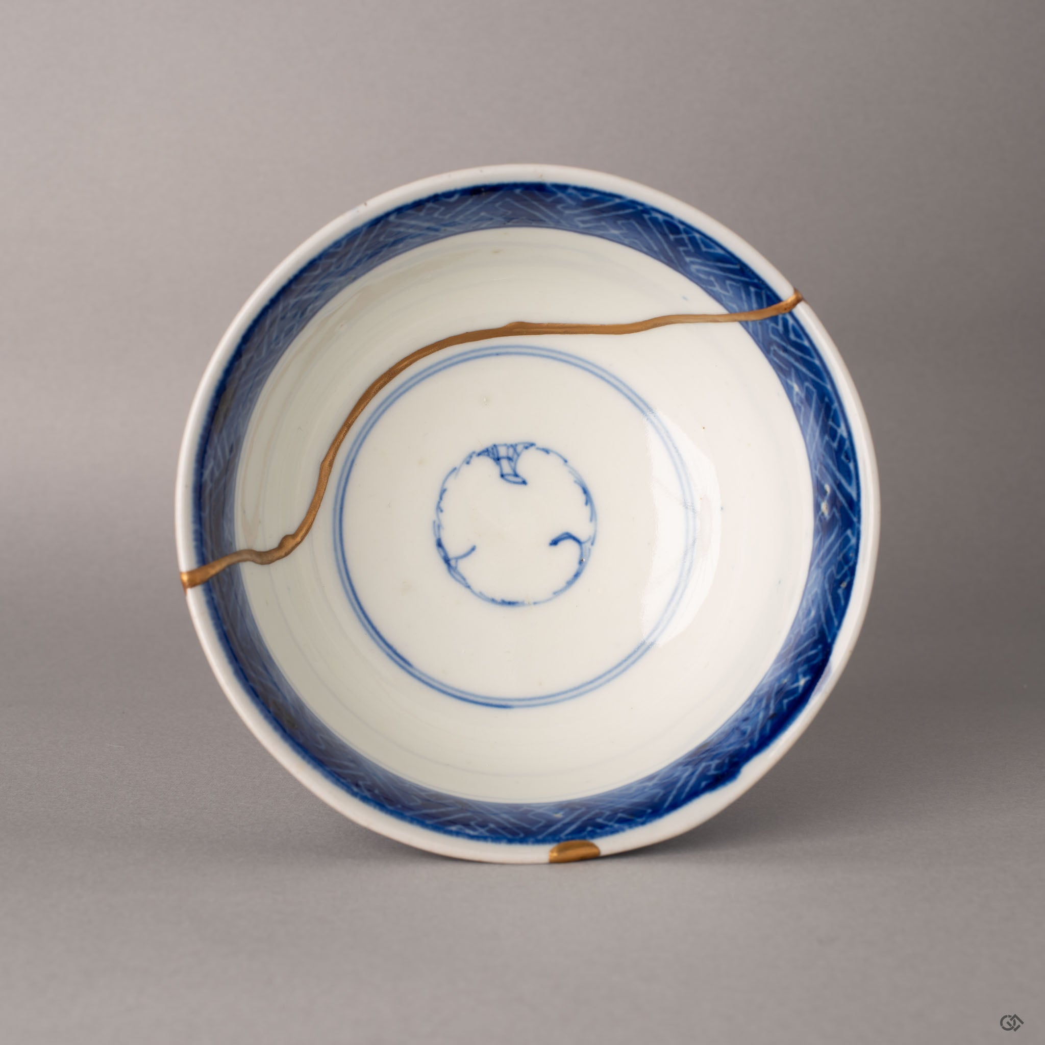 Top view of a Ko-Imari kintsugi bowl showing diamond patterns, gold seams, and sometsuke botanical painting, slow craft.