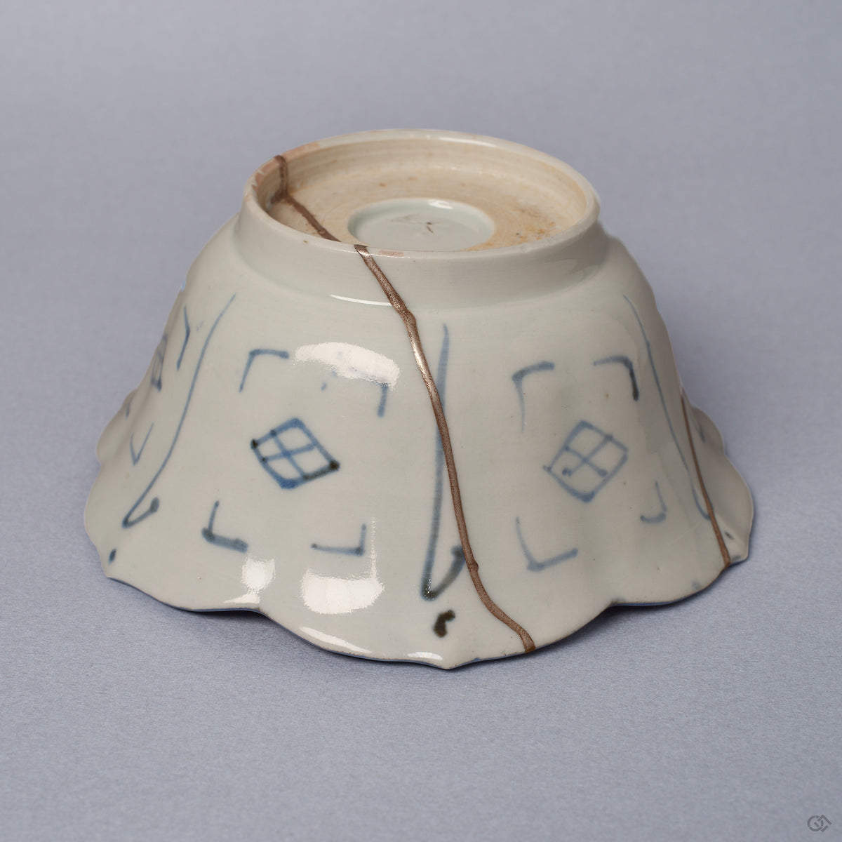 Side profile of a Ko-Imari kintsugi bowl, foliate rim and blue diamond-lattice exterior joined by a long pure silver seam, restored with natural urushi in Japan.