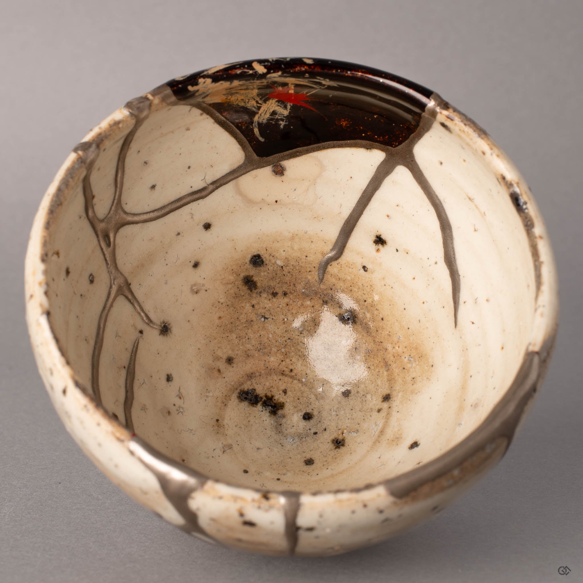 Close-up of nashiji technique inside a kintsugi Shigaraki cup, fine gold flecks suspended in translucent urushi lacquer creating a warm scattered glow, heritage luxury in every layer.