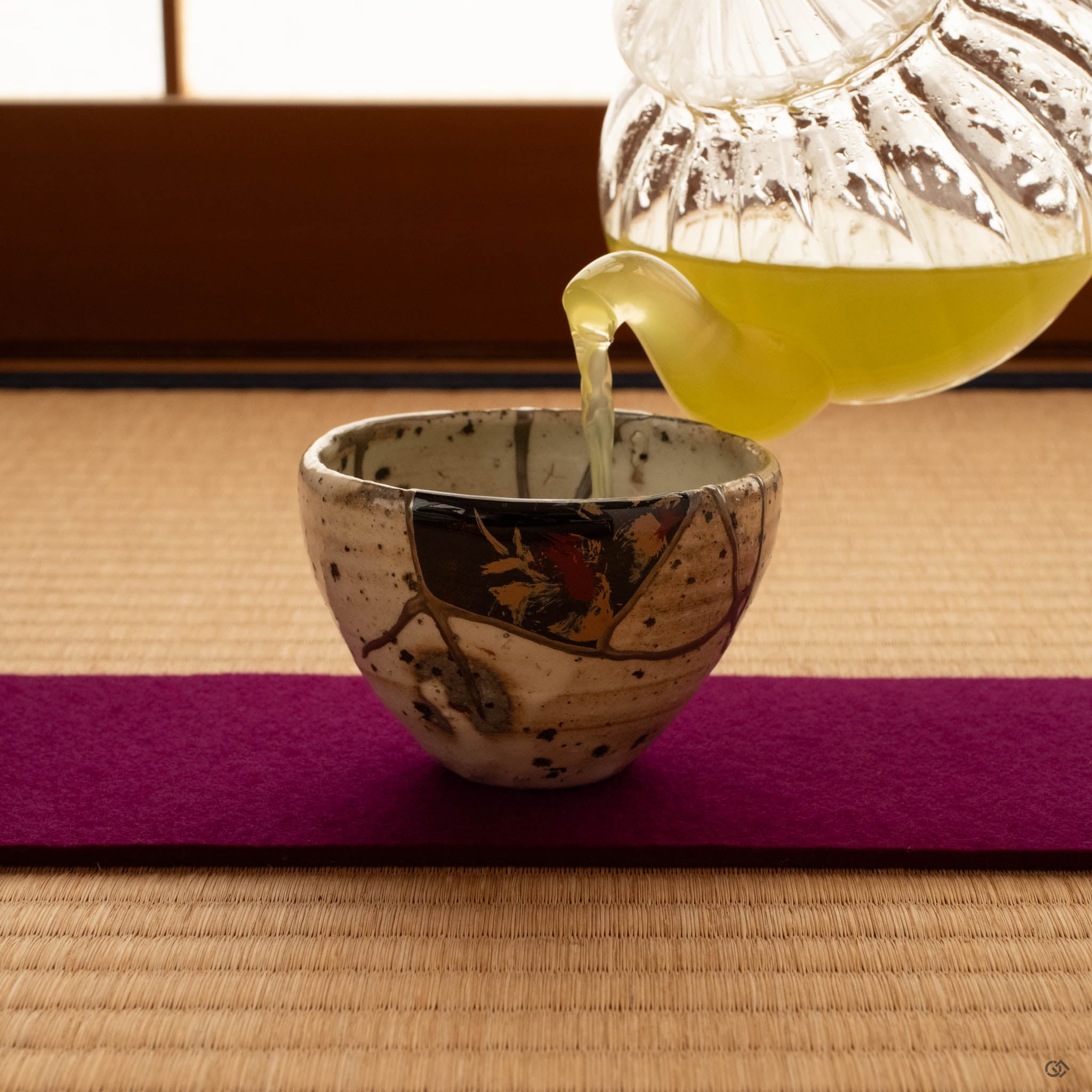 Kintsugi Shigaraki cup on tatami in a Japanese interior, silver seams and urushi-e painting catching natural light, a living philosophy at rest in its element.