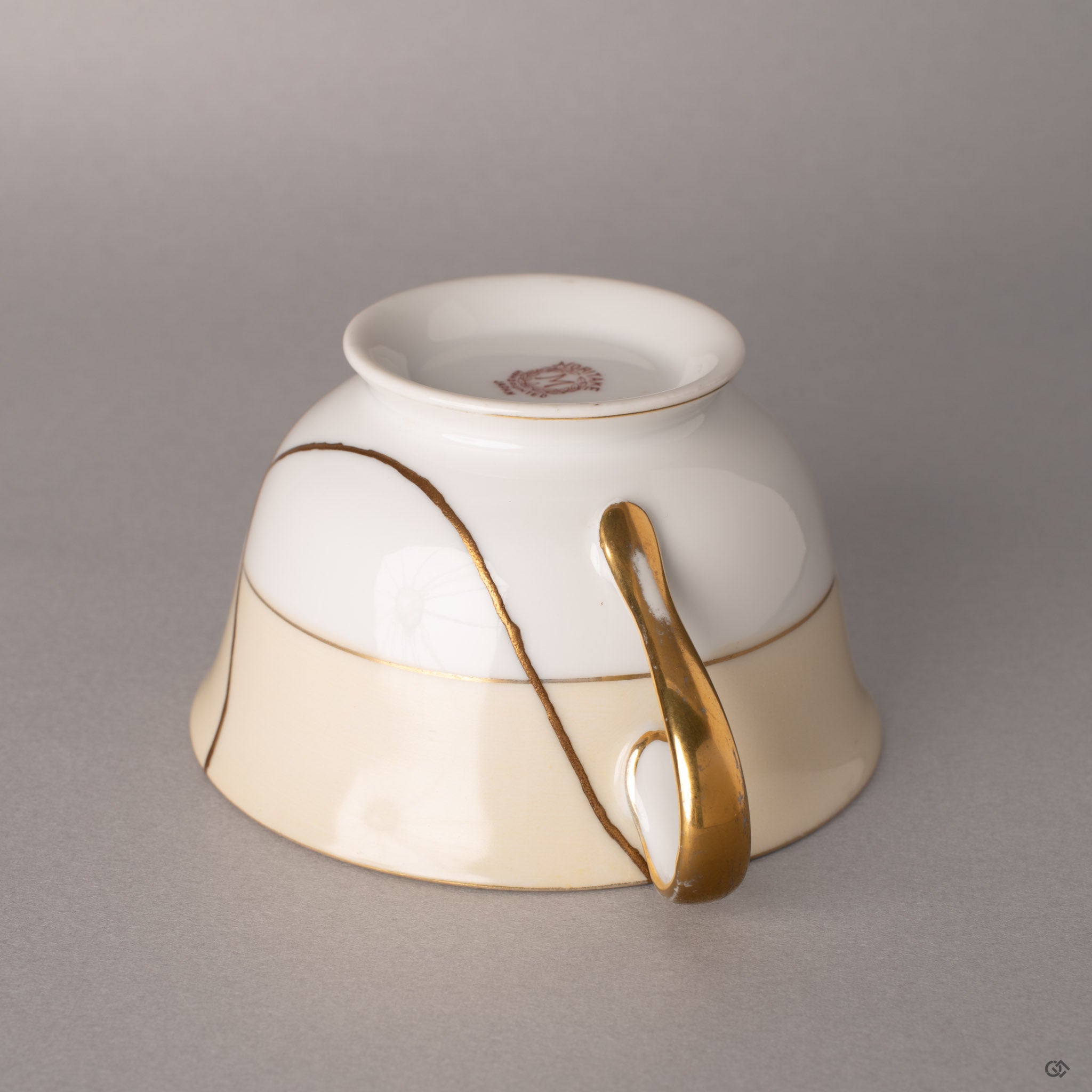 Gold kintsugi lines thread across ivory Noritake porcelain, each seam a quiet meditation on renewal.