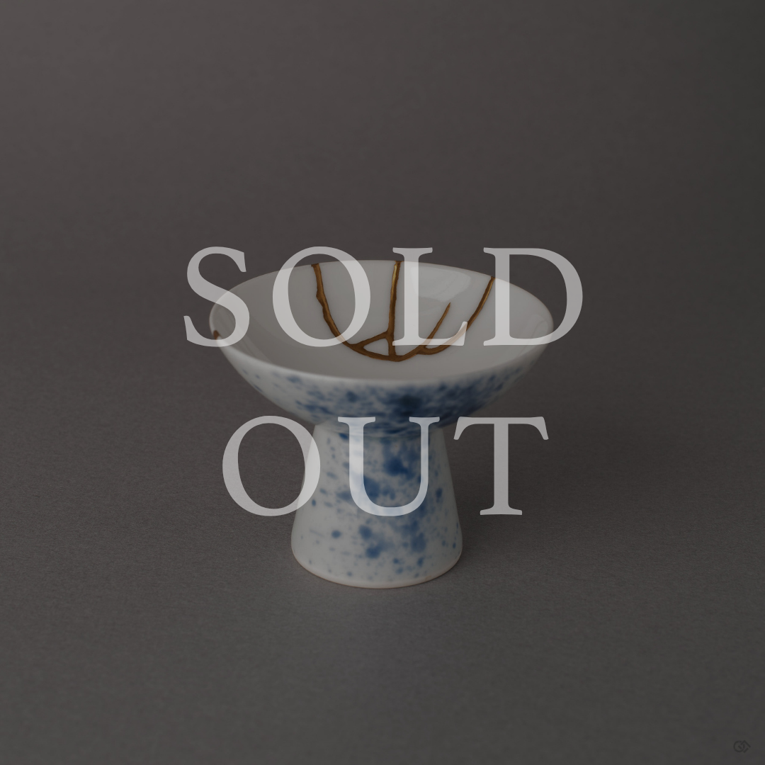 Sold out: Kintsugi Arita porcelain sake cup with 24K gold seams and sometsuke blue splatter glaze, footed pedestal form.