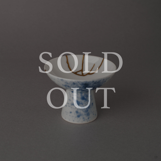 Sold out: Kintsugi Arita porcelain sake cup with 24K gold seams and sometsuke blue splatter glaze, footed pedestal form.