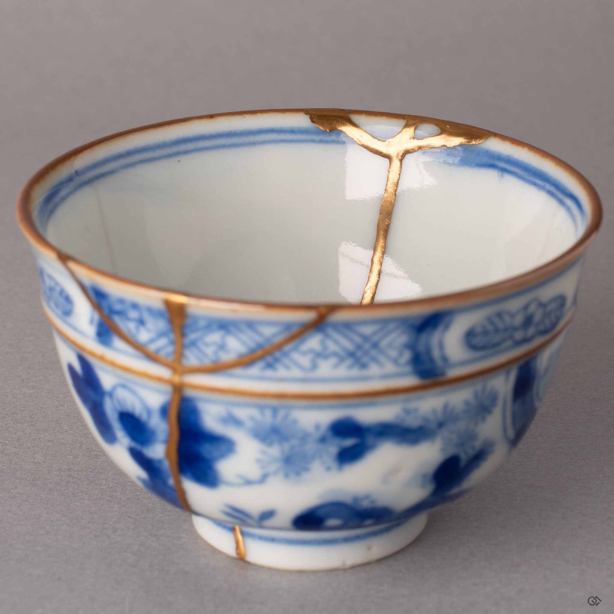 Detail of kintsugi chip restoration inside Ko-Imari cup, 24K gold and urushi lacquer forming a precise edge, one-of-a-kind artistry.