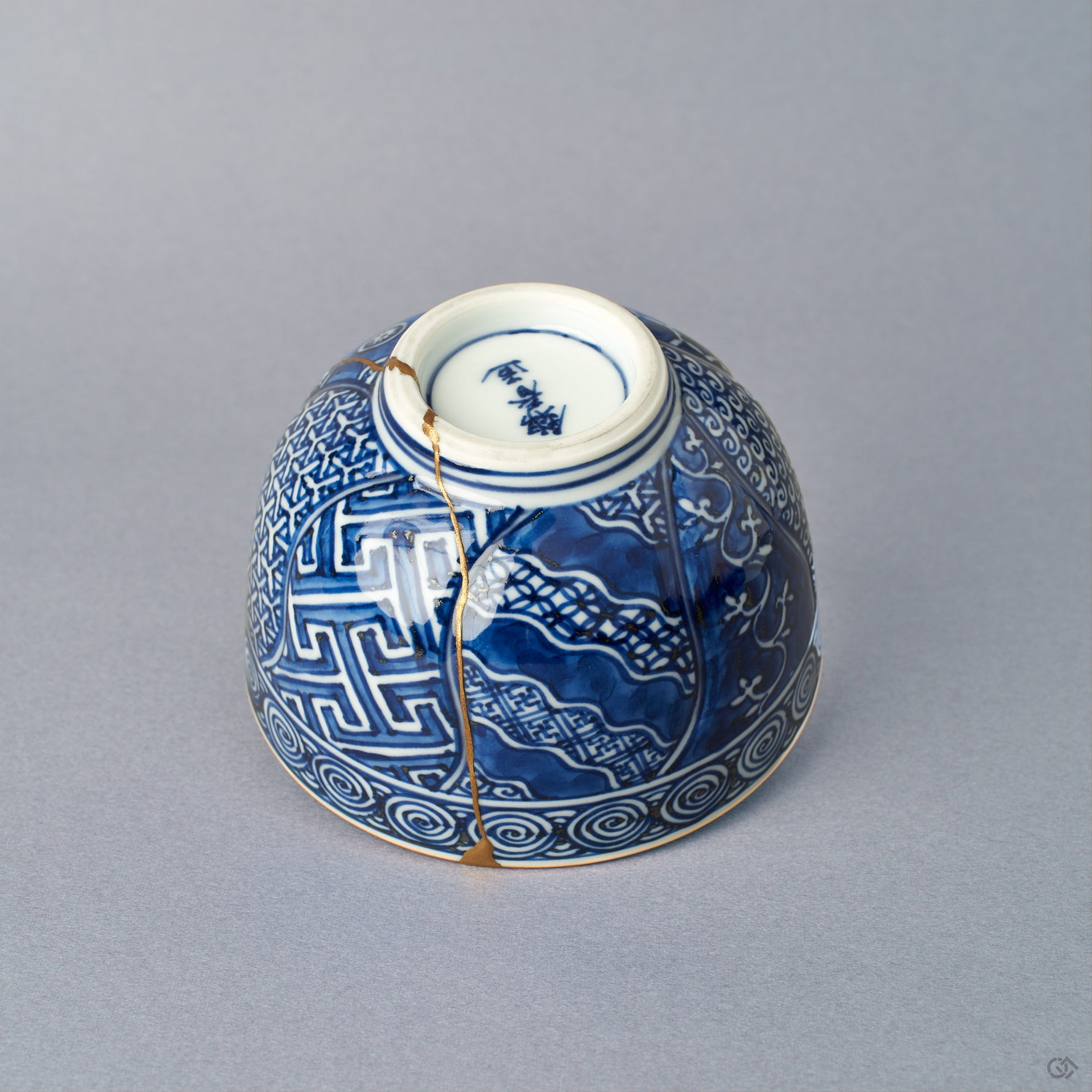 Second side view of the Kyoto ware kintsugi cup, cobalt sometsuke komon patterning, continuous 24K gold restoration seam, gold-banded lid rim.