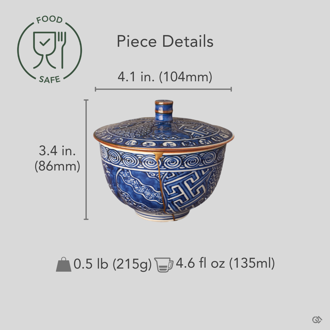 Kyoto ware kintsugi cup held in hand for scale, lidded sometsuke blue porcelain with 24K gold restoration seam, showing the covered cup's size.
