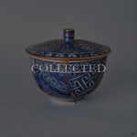Kyoto ware porcelain cup in sometsuke cobalt blue with Uzu-komon swirls, a single continuous kintsugi seam in 24K gold from rim to foot, lidded form with gold-banded rim. Collected.