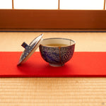 Kyoto ware kintsugi cup set on tatami, sometsuke cobalt blue porcelain with a single 24K gold seam and fitted lid, quiet tea-setting context.