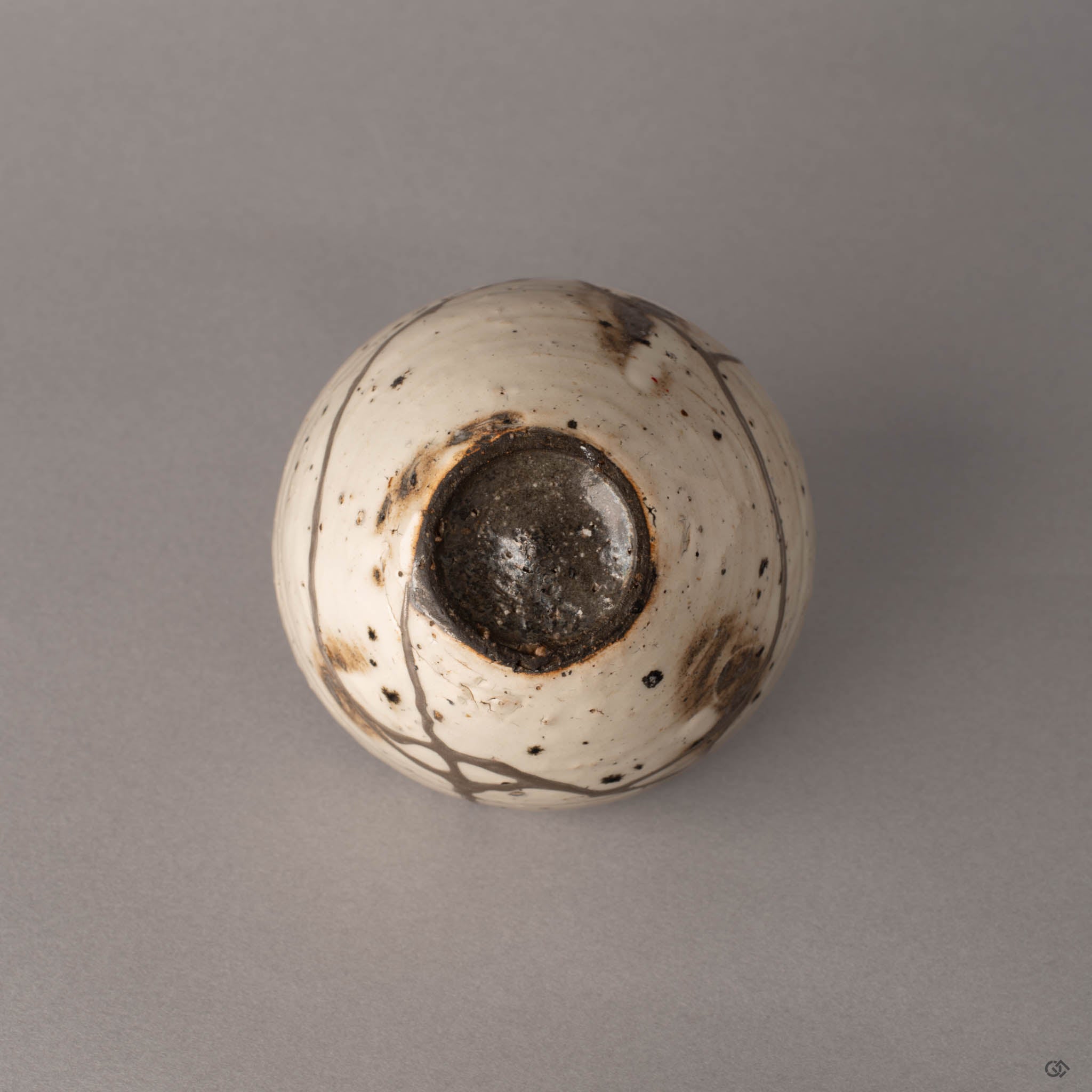 Bottom view of kintsugi Shigaraki cup showing unglazed earthenware foot and silver-finished seams, crafted resilience.