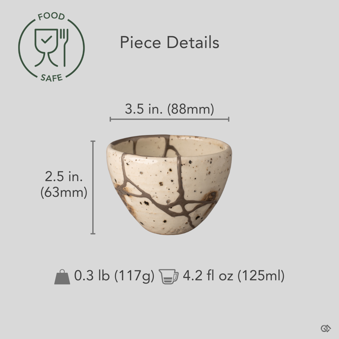 Silver kintsugi Shigaraki cup held for scale, showing the rounded form and branching restoration, one of a kind.