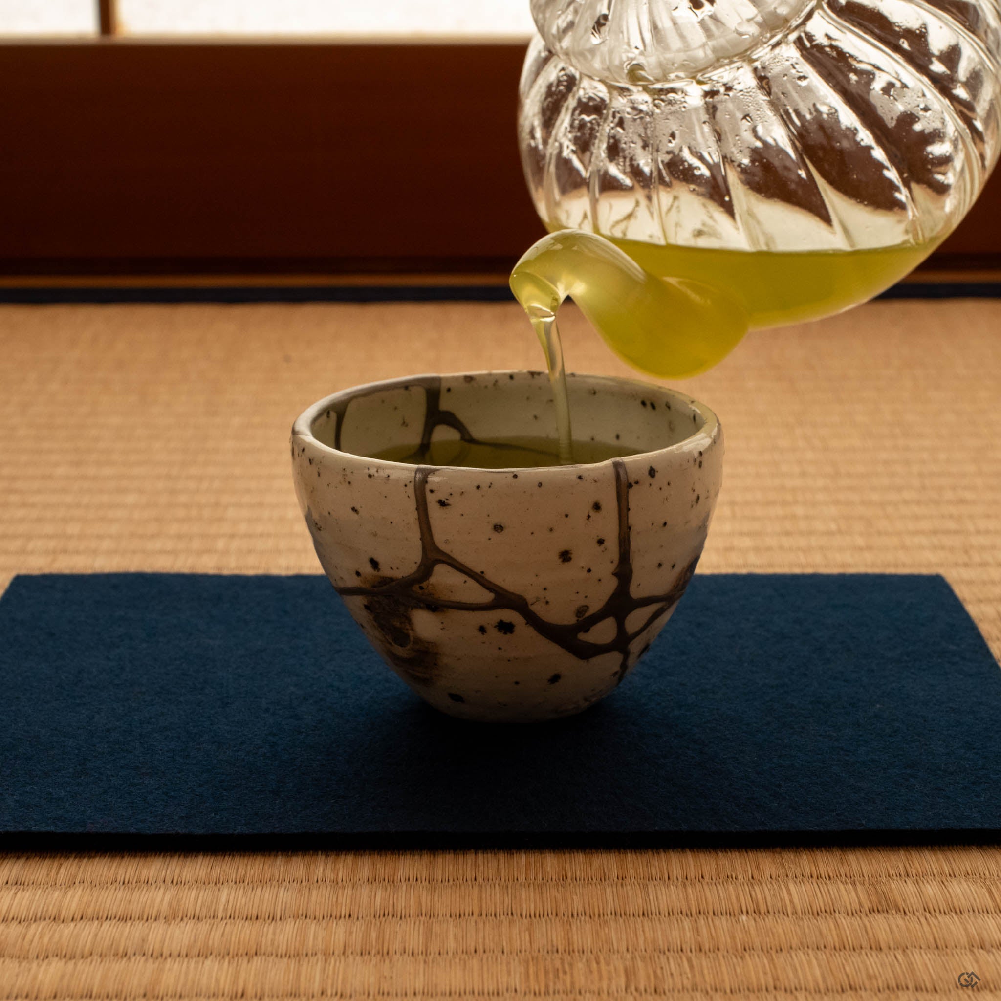 Kintsugi Shigaraki cup on tatami mat in natural light, silver seams glowing softly, a moment of contemplation