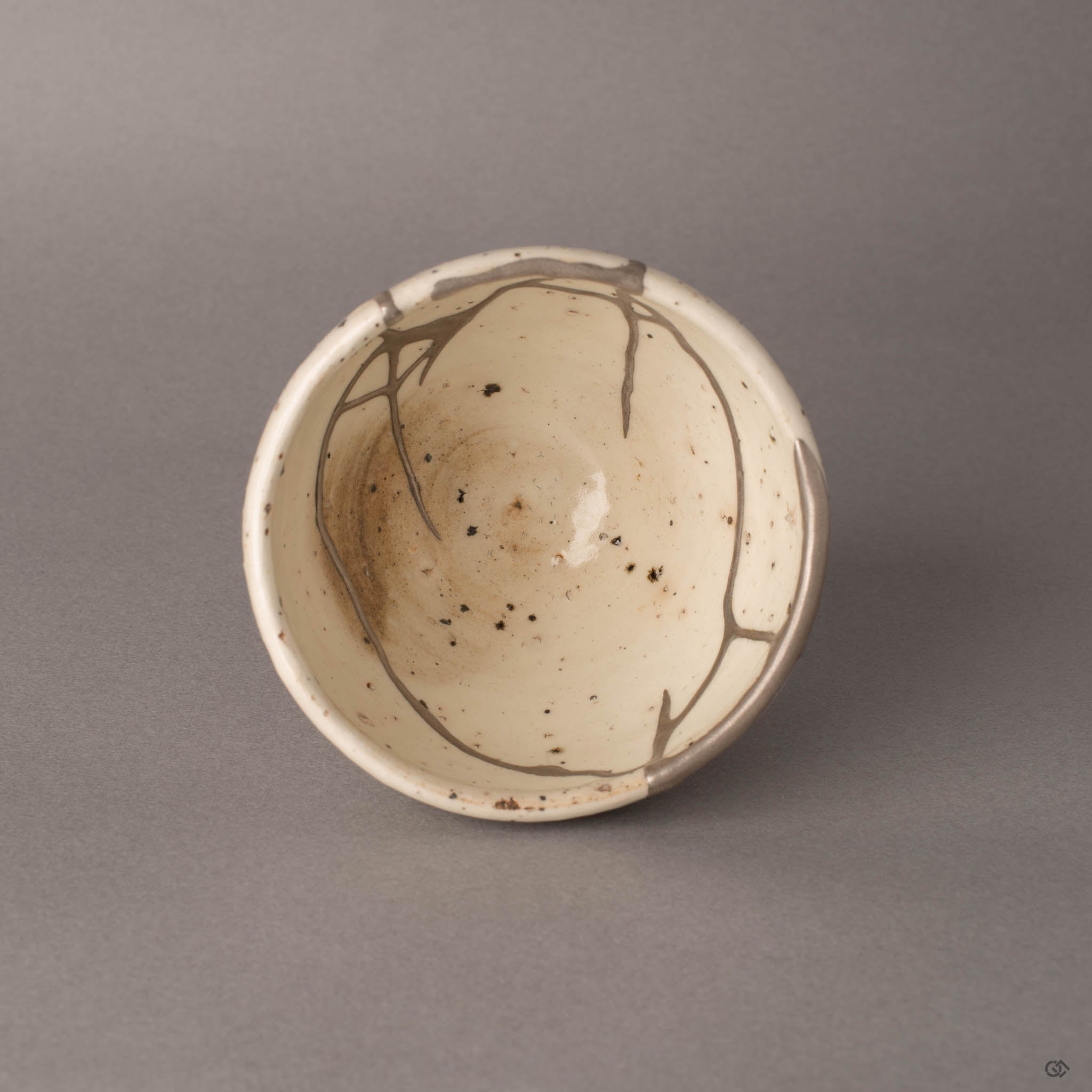 Top view of silver kintsugi Shigaraki cup showing the full pattern of restoration across the interior, heritage made visible.