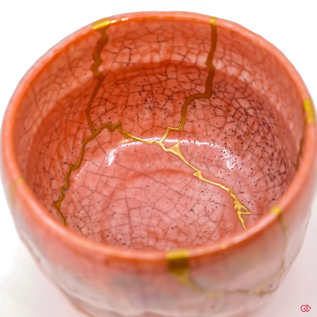 Close-up of 24k gold Kintsugi repair, showing the fine texture and seamless integration with the pottery.