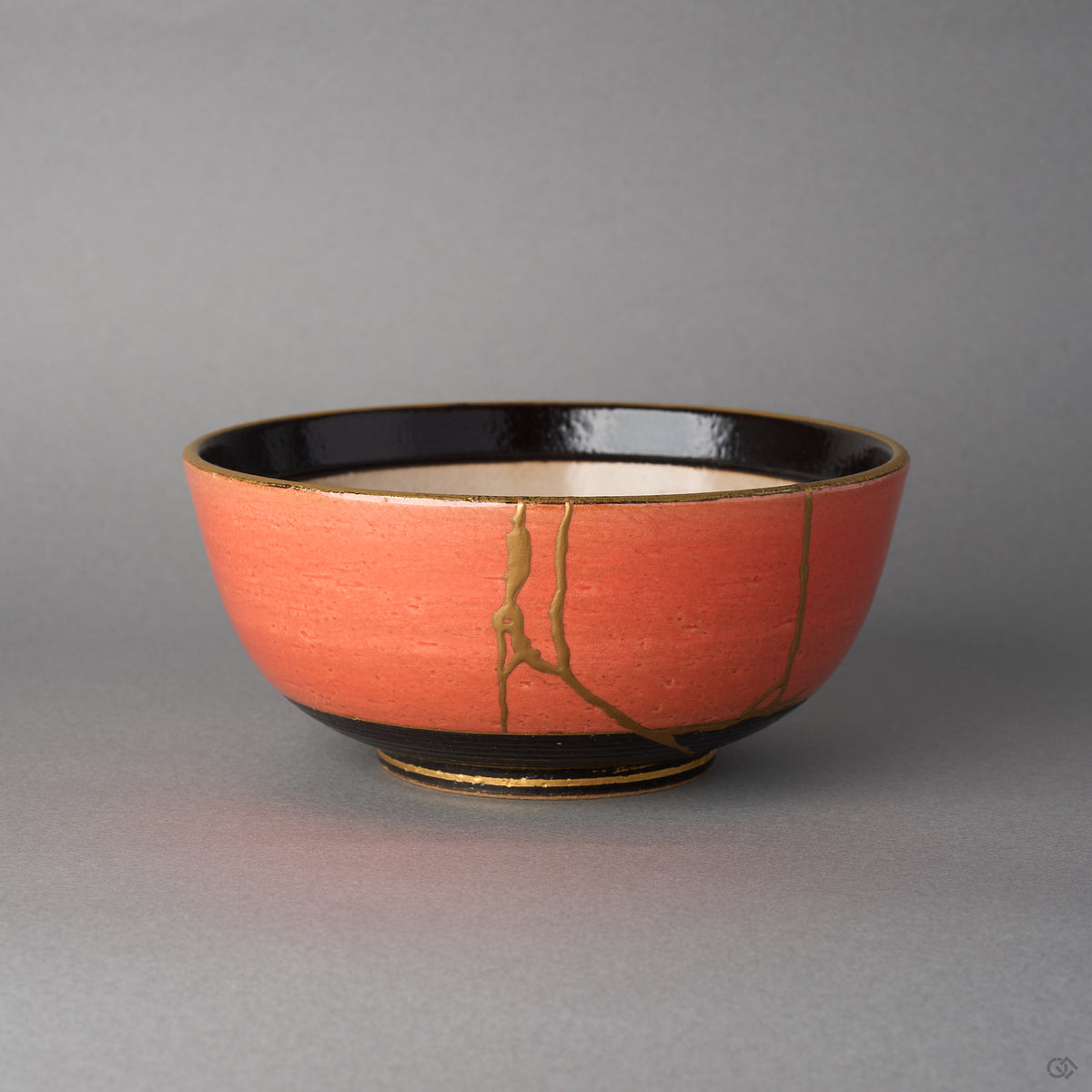 Kintsugi Arita ware bowl in vermilion glaze, rejoined with natural urushi, two 24K gold seams on the outer wall, front view.