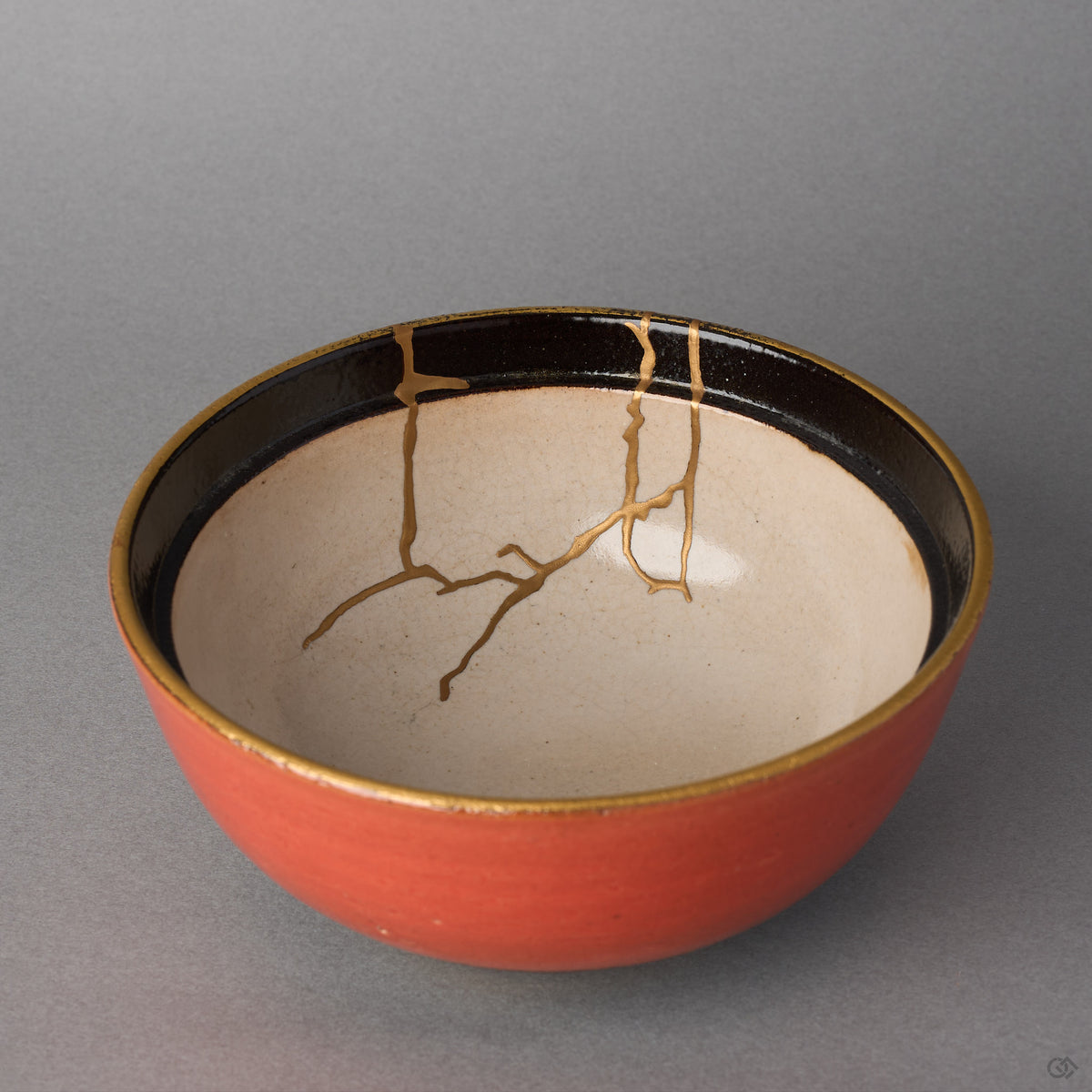 Kintsugi Arita ware bowl interior in pale cream, rejoined with natural urushi, 24K gold seams branching down from the black rim, interior close-up.