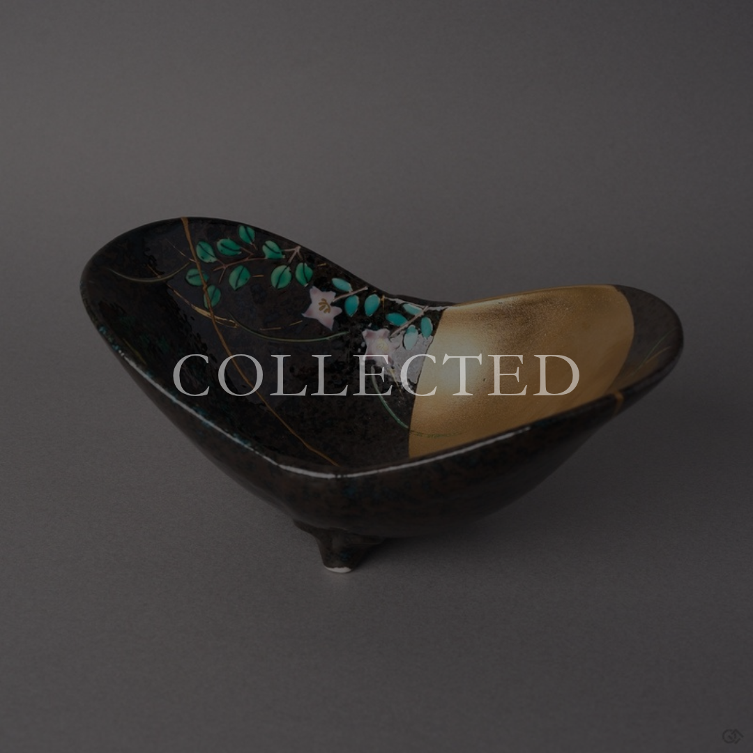 Kintsugi Arita ware bowl in black glaze with autumn grasses and a gold moon, rejoined with natural urushi, one 24K gold seam at the rim, front view. Collected.