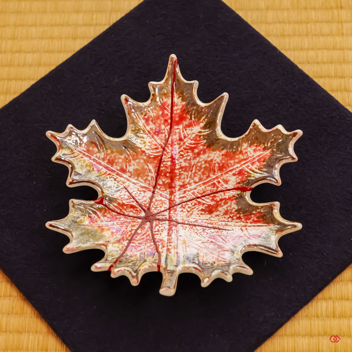 A slow-panning video showcasing the finished Kintsugi plate resting upon a deep navy blue felt cloth. The elegant presentation highlights the piece's serene presence and its harmony with traditional Japanese aesthetics.