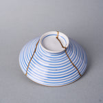 Kintsugi bowl lid in Arita porcelain from the reverse side, natural urushi and 24K gold lines running from the ring knob to opposite edges.