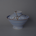 Kintsugi bowl with lid in Arita sometsuke porcelain, natural urushi and 24K gold lines descending the ringed lid, front view. Collected.