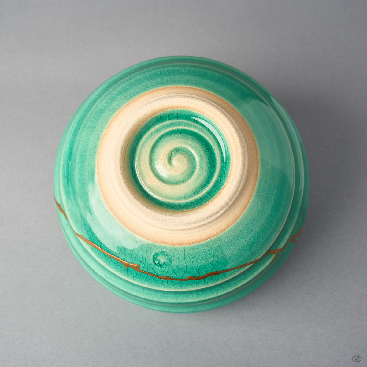 Kintsugi matcha bowl base shows the unglazed foot ring and a glazed spiral carved into the clay, the 24K gold line visible at the wall.