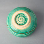 Kintsugi matcha bowl base shows the unglazed foot ring and a glazed spiral carved into the clay, the 24K gold line visible at the wall.