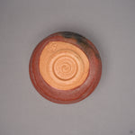 Kintsugi matcha bowl in Raku-style Kyoto ware turned over, buff unglazed foot with a coiled spiral and a seal, natural urushi and 24K gold seams above.