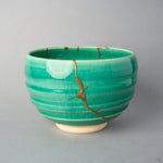 Kintsugi matcha bowl in Kyoto ware: a branching seam of natural urushi and 24K gold descends the emerald crackle glaze from the rim, front view.