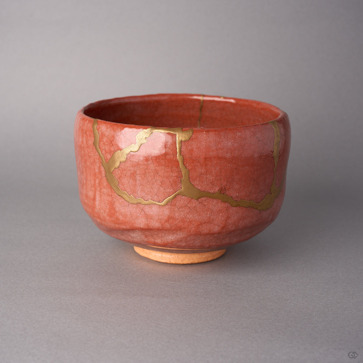 Kintsugi matcha bowl in Raku-style Kyoto ware with crackled vermilion glaze, rejoined with natural urushi, 24K gold seams looping across the front, front view.
