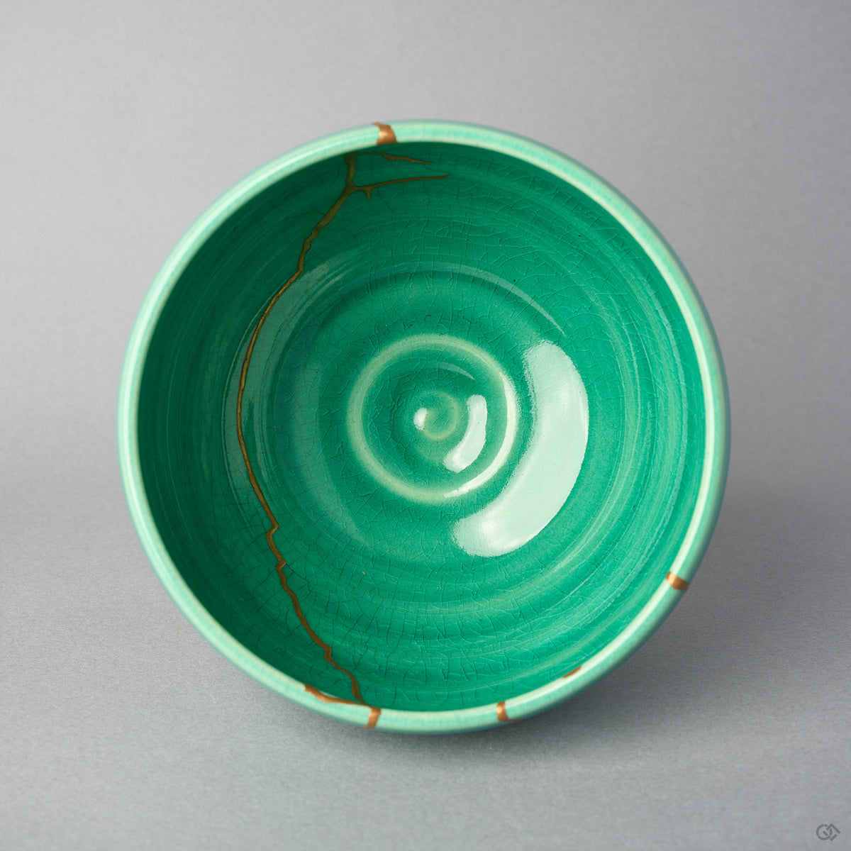 Kintsugi matcha bowl seen from above; an urushi and 24K gold line runs down the emerald crackle interior toward the center.