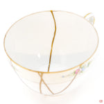 A close-up photo of an authentic Kintsugi pottery piece, showing the detail of its repairs and craftsmanship.