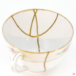 A close-up photo of an authentic Kintsugi pottery piece, showing the detail of its repairs and craftsmanship.
