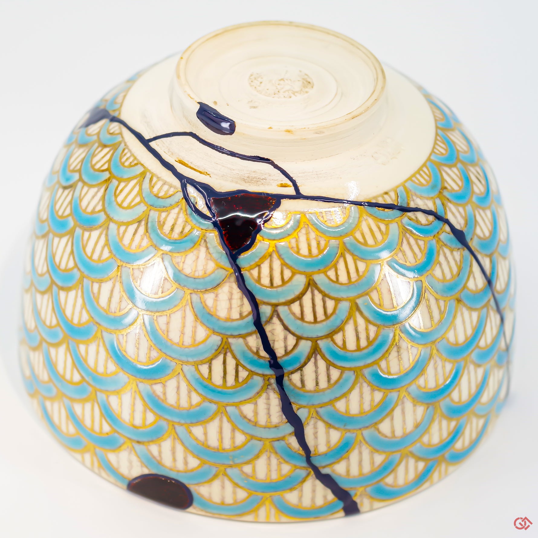 A close-up photo of an authentic Kintsugi pottery piece, showing the detail of its repairs and craftsmanship.