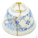 Intricate Kintsugi repair detail, highlighting the texture of gold on a restored ceramic piece.