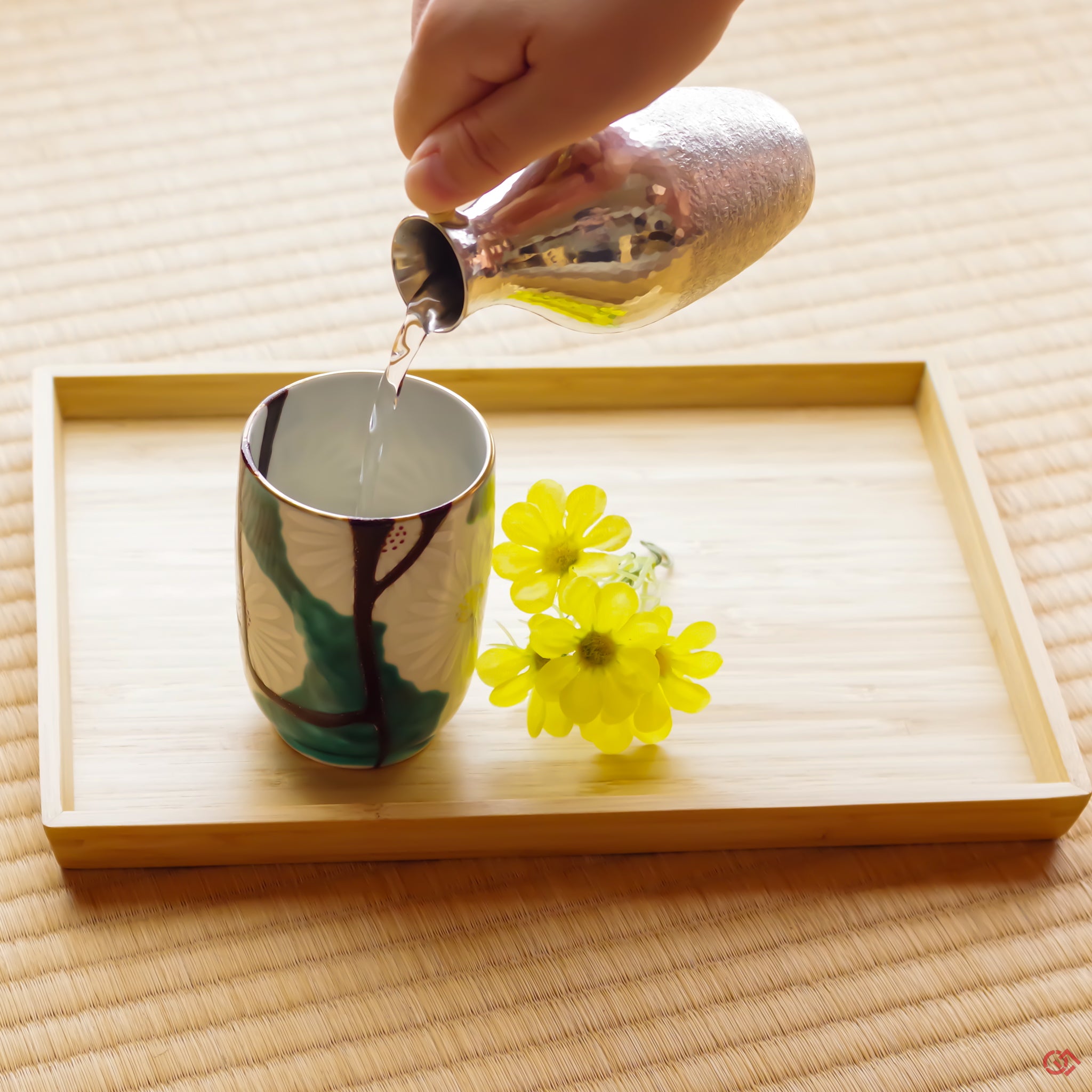 A photo of an authentic Kintsugi pottery piece being used in a real-world setting, such as a cup of sake being poured into a Kintsugi teacup.