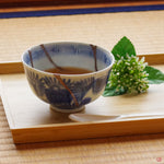 A photo of an authentic Kintsugi pottery piece being used in a real-world setting, such as a cup of soup being poured into a Kintsugi cup.