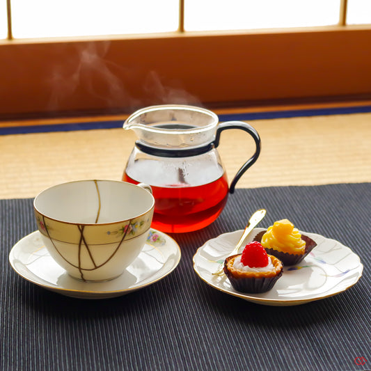 A photo of an authentic Kintsugi pottery piece being used in a real-world setting, such as a cuo of tea being poured into a Kintsugi teacup.