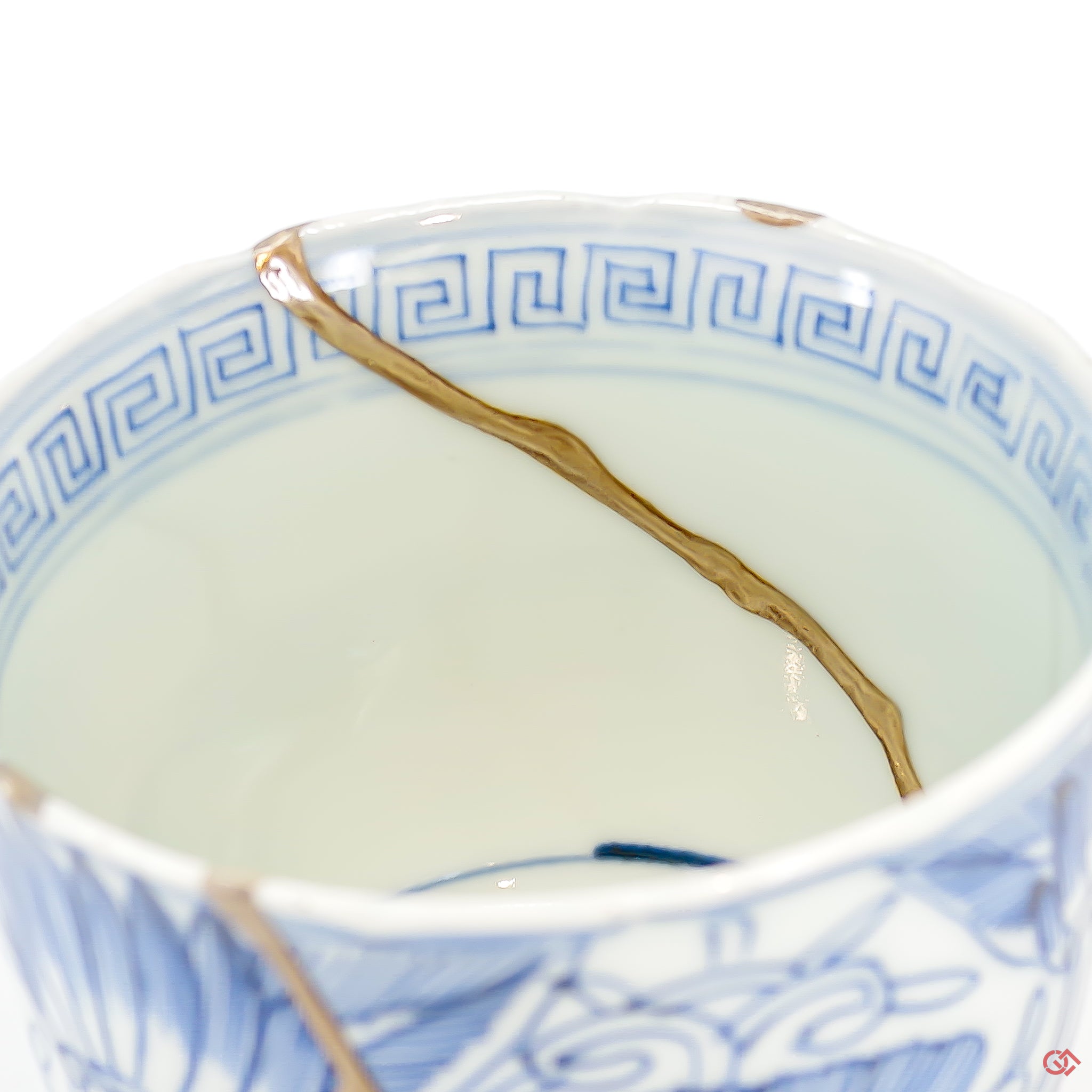 A close-up photo of an authentic Kintsugi pottery piece, showing the detail of its repairs and craftsmanship.