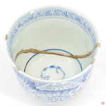 A close-up photo of an authentic Kintsugi pottery piece, showing the detail of its repairs and craftsmanship.