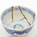 A close-up photo of an authentic Kintsugi pottery piece, showing the detail of its repairs and artisty. craftsmanship.