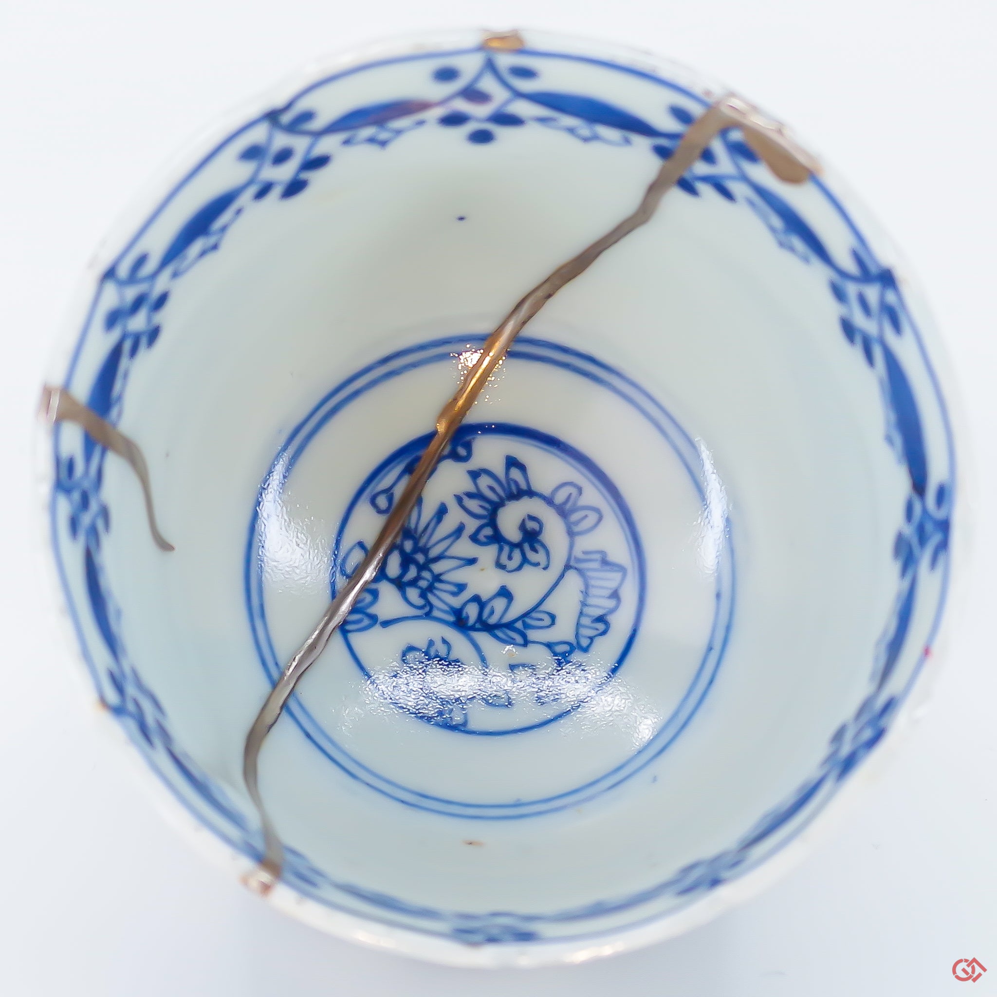 A close-up photo of an authentic Kintsugi pottery piece, showing the detail of its repairs and craftsmanship.