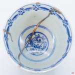 A close-up photo of an authentic Kintsugi pottery piece, showing the detail of its repairs and craftsmanship.